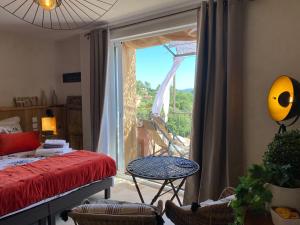 鲁西永Maison d'hôtes Une hirondelle en Provence的客房设有一张床和一个美景窗户。