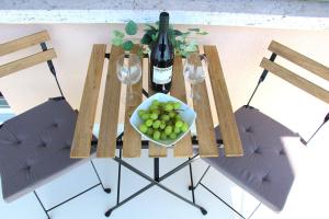 卢加诺Cozy apartment with Free Parking & close to Lake的一张桌子,上面放着一碗葡萄和一瓶葡萄酒
