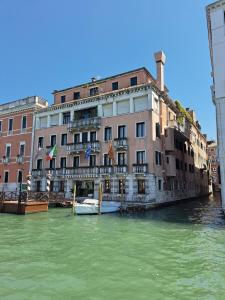 威尼斯西娜圣天使宫殿酒店的河里有楼房,水里有船