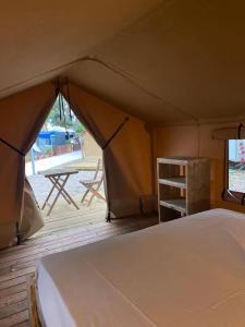 托里代巴拉KT-0094 Magnífica Tienda Tipi - Camping Miramar Playa的帐篷配有床和带桌子的甲板
