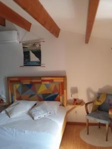 拉康提内勒Oléron côte ouest, 3 étoiles的一间卧室配有一张床和一把椅子