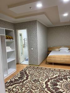 YakkasarayHiva的一间卧室配有一张床和一张大地毯