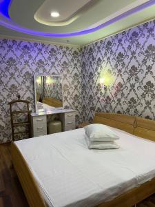 YakkasarayHiva的卧室配有白色的床和紫色墙壁