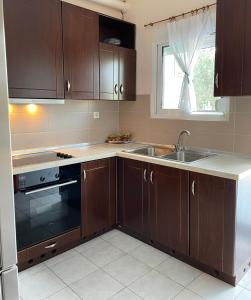 耶拉基尼Thomi's house.的厨房配有棕色橱柜、水槽和窗户。