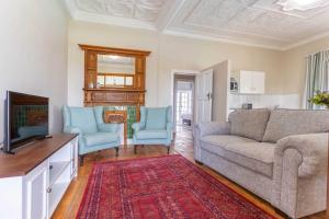 比勒陀利亚Middelberg Manor的客厅配有沙发和2把蓝色椅子