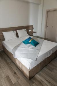 阿莫利亚尼岛elenamou seaview rooms的一张配有白色床单和蓝色枕头的大床