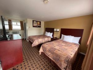 TweedPark Place Motel & Suites的酒店客房设有两张床和电视。