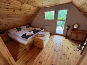 PliešovceChalupa v prírode的木制客房内的一间卧室,配有一张床