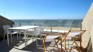 德哈恩DeHaanStudio的一张桌子和椅子,享有海滩美景