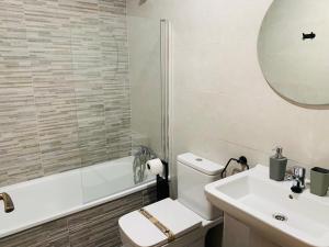 艾因萨Apartamentos Best Ainsa的一间带卫生间、水槽和镜子的浴室
