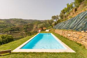 比索达雷加DouroParadise的一座位于田野中间的游泳池,设有石墙