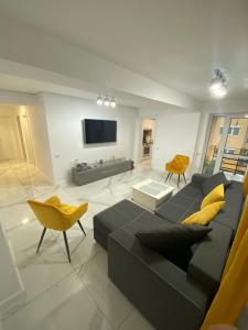 康斯坦察Bella Apartament的客厅配有黑色沙发和黄色枕头