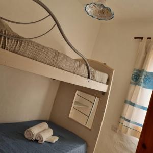 Porto IstanaLe Farfalle Appartamento in villa trifamiliare的一间卧室配有两张双层床和一盏灯。