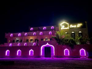 达哈布Casa d'Or Dahab PALAZZO的前面有紫色灯的建筑