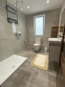 卢加Modern, Spacious, 3 Bedroom Apartment near Malta International Airport的带浴缸、卫生间和盥洗盆的浴室
