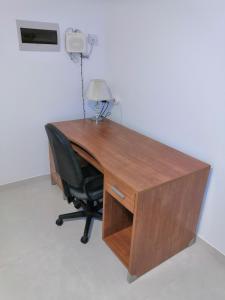 卢加Modern, Spacious, 3 Bedroom Apartment near Malta International Airport的一张带椅子和台灯的木桌