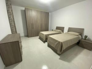 卢加Modern, Spacious, 3 Bedroom Apartment near Malta International Airport的一间卧室设有两张床和木制橱柜