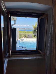 内里吉恩Podgora Experience Suite with jacuzzi的享有游泳池和大海美景的窗户