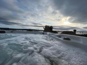 内里吉恩Podgora Experience Suite with jacuzzi的围栏旁的雪覆盖的热水浴池