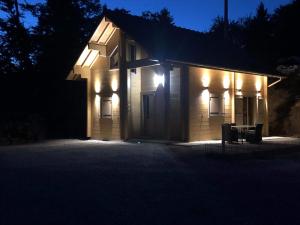 AlièzeForest Jura Lodge - Chalet des sapins的一座建筑,晚上有灯