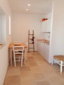 奥特朗托La Noscia - Le Dimore di Thesia的厨房配有桌子和桌椅