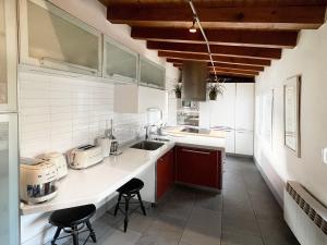 维多利亚-加斯特伊兹Luxury Arquillos Vitoria的厨房配有白色橱柜和带凳子的台面