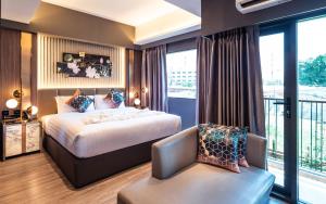 曼谷The One Smart Living的配有一张床和一把椅子的酒店客房
