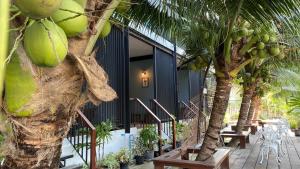 Damnoen Saduak麦克瓦达莫恩度假酒店的一座棕榈树、桌椅的建筑