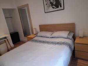 雷丁Lovely Home with full en-suite double bed rooms的卧室配有白色的床和木制床头板