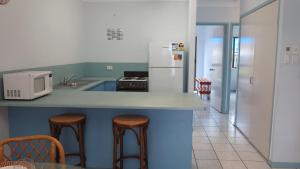 阿卡狄亚Magnetic Shores Unit 2的厨房配有带凳子的柜台和冰箱。