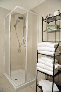 罗马罗坎达阿尔维米纳尔旅馆的浴室里设有淋浴和一堆毛巾