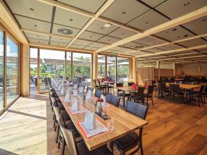 吕蒂斯堡洛伊斯利塔夫特维尔酒店的用餐室设有桌椅和窗户。