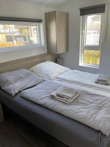 沙博伊茨Beach Chalet的卧室内的两张床和毛巾