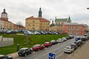 卢布林Apartament Malinowy Świętoduska 12的一条城市街道,汽车停在建筑前