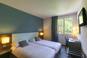 卢尔德密拉蒙酒店的酒店客房设有两张床和窗户。
