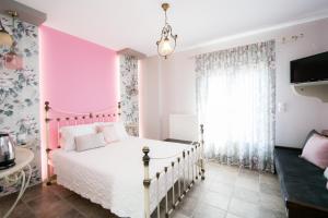 桑加拉达彩虹宾馆的粉红色和白色的卧室,配有床