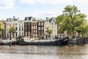 阿姆斯特丹Studio next to Skinny Bridge near Rembrandtsquare的一群船停靠在建筑物前的河上