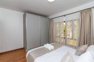 内罗毕CySuites Apartment Hotel的一间卧室设有一张床和一个大窗户