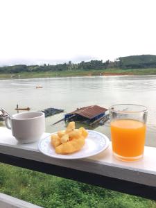 桑卡武里Baan Dongsak River view的一小盘食物和一杯橙汁