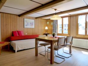 劳特布龙嫩格罗斯奥恩劳特布瑞恩公寓酒店的一间卧室配有桌子和一张红色沙发的床