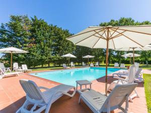 苏韦雷托Apartment Marrone by Interhome的一个带椅子和遮阳伞的游泳池