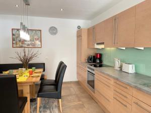 奥贝劳Apartment Sonnseit Living - WIL220 by Interhome的厨房配有木柜、木桌和用餐室