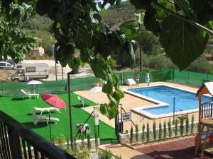 Margarida磨坊乡村酒店及餐厅的一个带野餐桌和遮阳伞的游泳池
