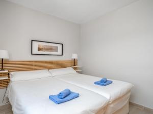 锡蒂奥卡拉翁达Apartment Calahonda Royale by Interhome的白色床上配有2条蓝色毛巾