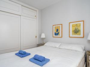 锡蒂奥卡拉翁达Apartment Calahonda Royale by Interhome的一间白色卧室,床上配有2条蓝色毛巾