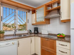 锡蒂奥卡拉翁达Apartment Calahonda Royale by Interhome的厨房配有白色橱柜、水槽和窗户。