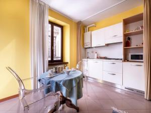 弗留利地区圣达尼埃莱Apartment Squisleep-1 by Interhome的带小桌子的厨房和带黄色墙壁的厨房