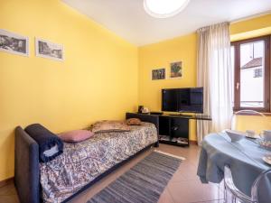 弗留利地区圣达尼埃莱Apartment Squisleep-1 by Interhome的一间卧室配有一张床、一张桌子和一台电视