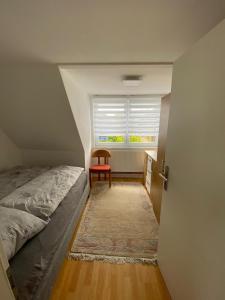 沙博伊茨Strandnähe的一间卧室配有一张床和一个带椅子的窗户