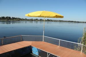利文斯顿Kayube Zambezi River House的一条在河上带黄伞的船